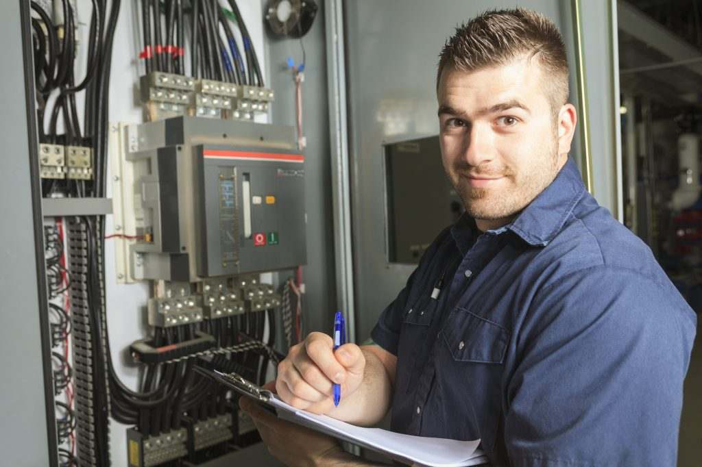Engineer reviewing documentation next to a distribution board